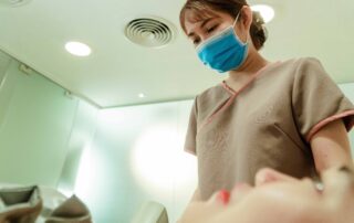 Medical practitioner with a mask on and a patient lying on a table