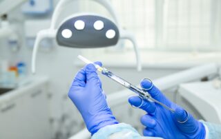 med spa practitioner holding a botox needle wearing blue gloves