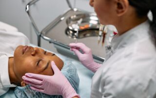 esthetician with pink gloves injecting a patient at a medspa
