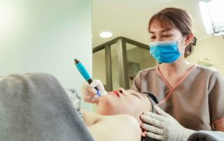 Esthetician performing dermabrasion treatment on a patient